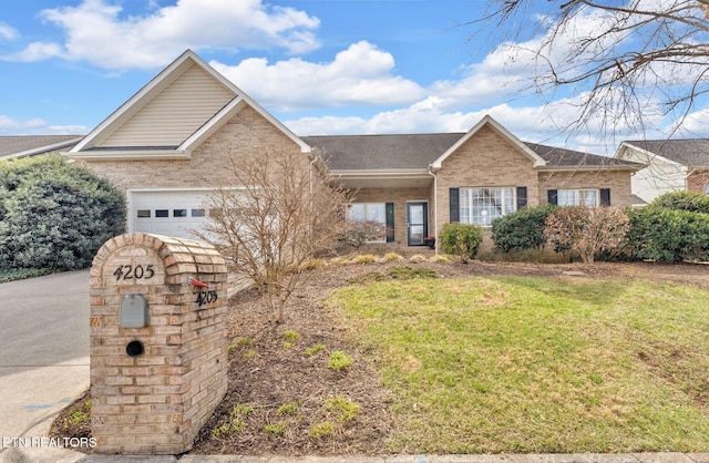 ranch-style home featuring a front yard, a garage, and brick siding