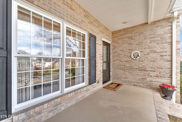 exterior space with brick siding and a porch