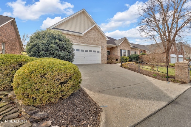 single story home featuring brick siding, an attached garage, concrete driveway, and fence