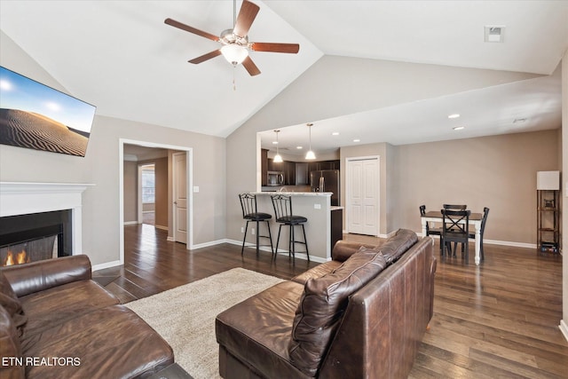 living room featuring baseboards, dark wood-style floors, visible vents, and a lit fireplace