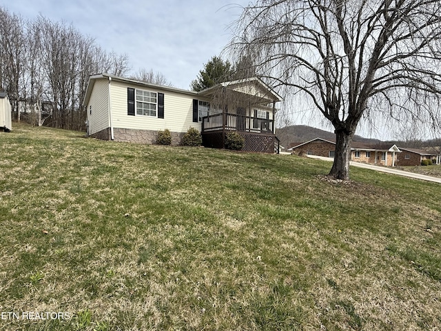 view of front of home with a deck and a front yard