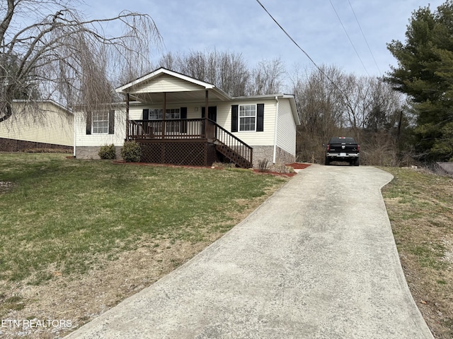 view of front facade featuring covered porch, concrete driveway, and a front lawn