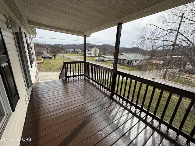 wooden terrace with a yard and a residential view