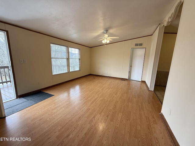 interior space with visible vents, crown molding, light wood-type flooring, and a ceiling fan