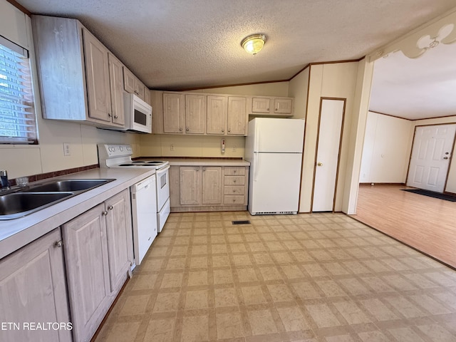 kitchen featuring white appliances, light floors, lofted ceiling, and a sink