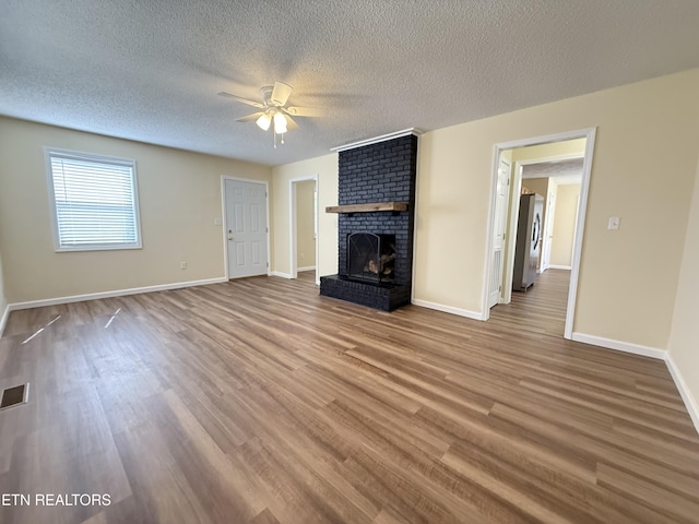 unfurnished living room featuring ceiling fan, baseboards, wood finished floors, and a fireplace