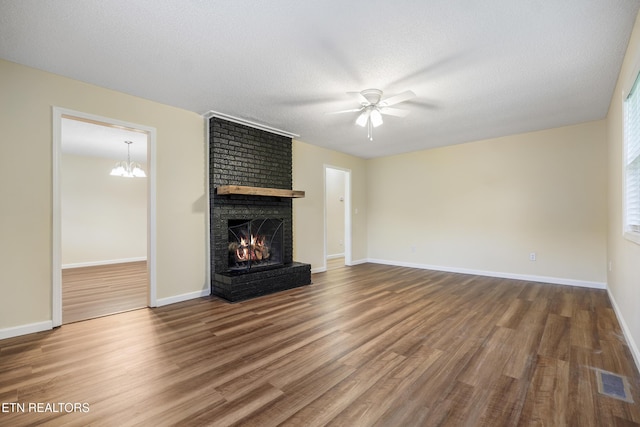 108 Burke St, Pennington Gap, VA 24277 - unfurnished living room with visible vents, ceiling fan with notable chandelier, wood finished floors, and a brick fireplace