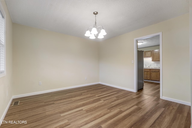 108 Burke St, Pennington Gap, VA 24277 - spare room with visible vents, baseboards, an inviting chandelier, and wood finished floors