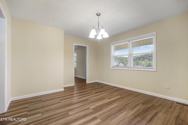108 Burke St, Pennington Gap, VA 24277 - unfurnished room with a notable chandelier, visible vents, baseboards, and wood finished floors