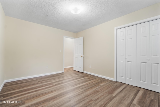108 Burke St, Pennington Gap, VA 24277 - unfurnished bedroom featuring a textured ceiling, wood finished floors, a closet, and baseboards