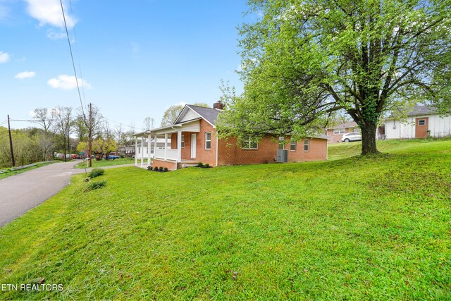 108 Burke St, Pennington Gap, VA 24277 - view of front of home with brick siding, a porch, a chimney, and a front lawn