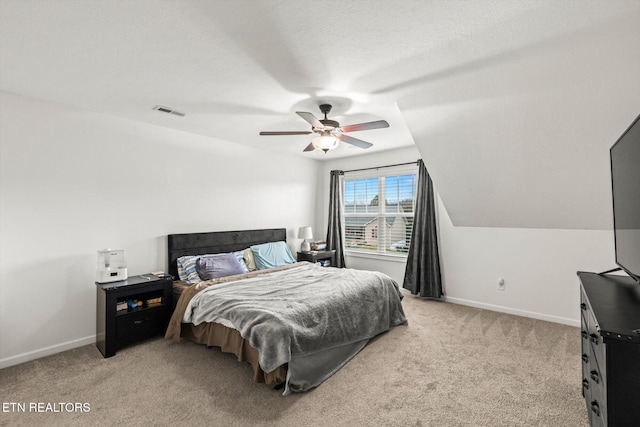 bedroom featuring light carpet, visible vents, baseboards, and vaulted ceiling