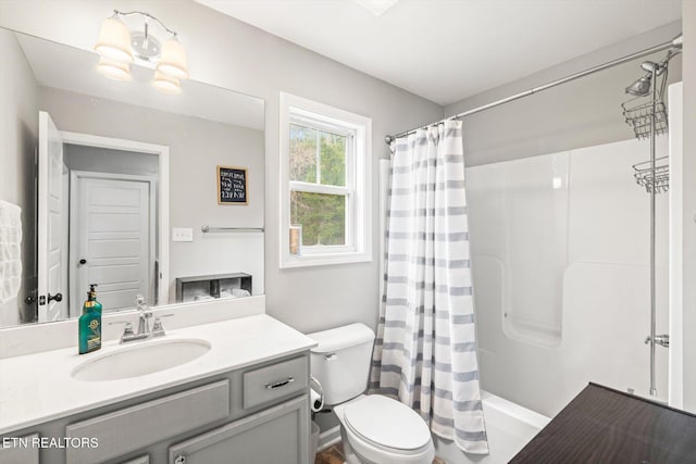 bathroom with a shower with shower curtain, toilet, and vanity