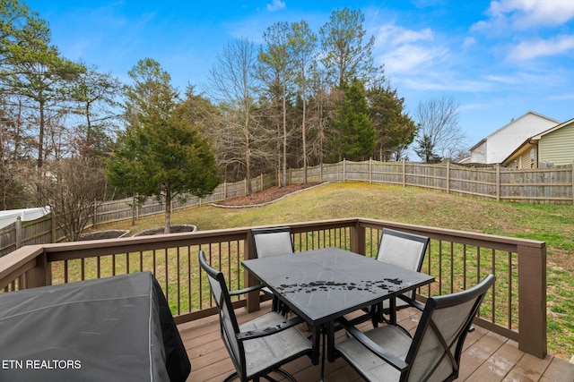 wooden deck featuring area for grilling, outdoor dining area, a lawn, and a fenced backyard