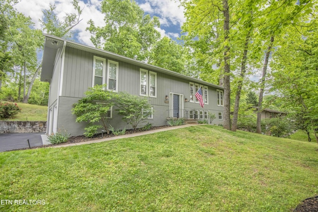 split foyer home featuring driveway and a front yard