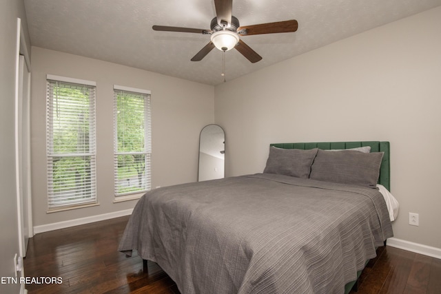 bedroom featuring ceiling fan, hardwood / wood-style flooring, and baseboards