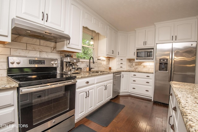 kitchen featuring under cabinet range hood, a sink, white cabinetry, dark wood-type flooring, and appliances with stainless steel finishes