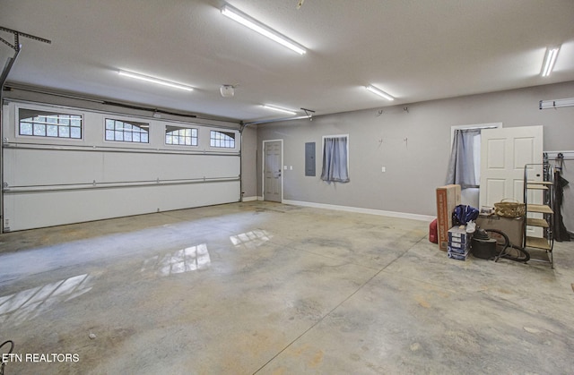 garage with electric panel and baseboards