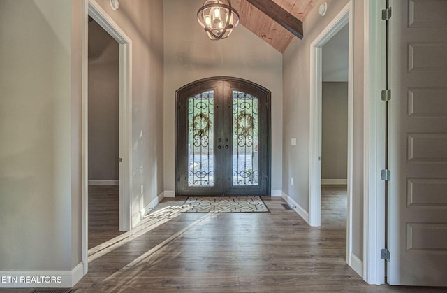 foyer entrance with dark wood-style floors, wooden ceiling, french doors, and lofted ceiling with beams