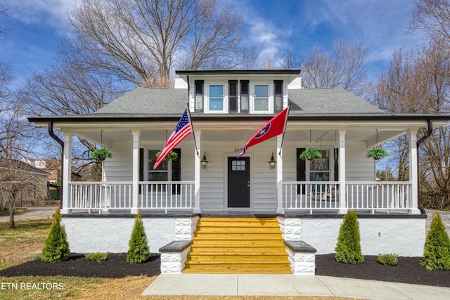 bungalow with covered porch and a shingled roof