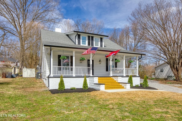 bungalow featuring a chimney, a porch, a front yard, and a shingled roof