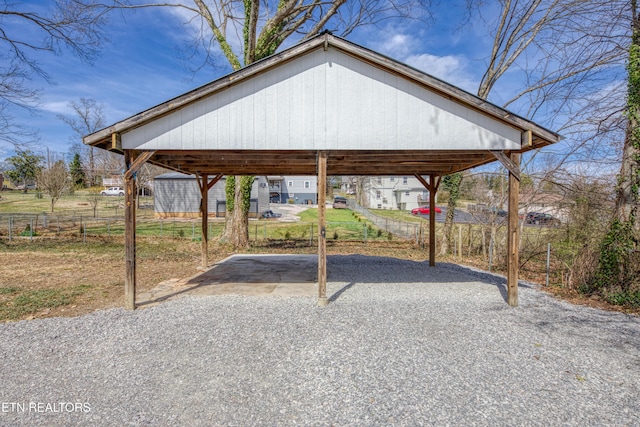 exterior space featuring a detached carport, driveway, and fence