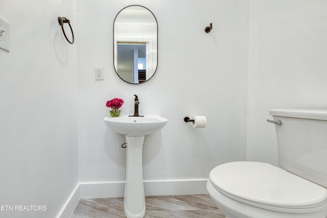 bathroom with toilet and baseboards