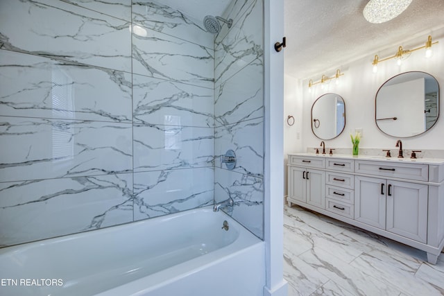 full bathroom with double vanity, marble finish floor, a textured ceiling,  shower combination, and a sink