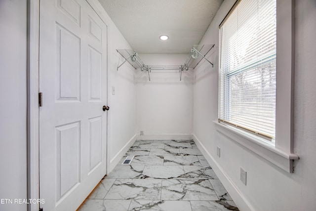 walk in closet with marble finish floor