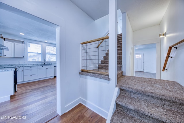 stairway with recessed lighting, baseboards, and wood finished floors