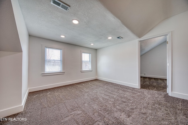 spare room with visible vents, a textured ceiling, baseboards, and carpet floors