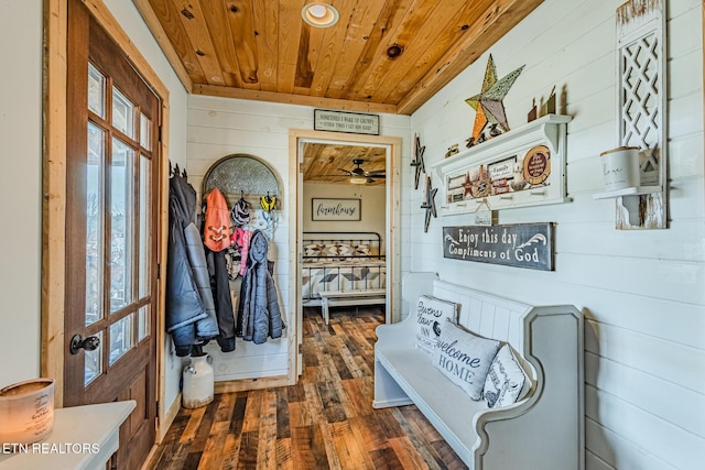 interior space with dark wood-type flooring, wood ceiling, and wooden walls