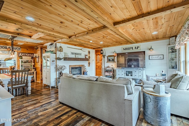 living area featuring wood finished floors, wood ceiling, wood walls, a glass covered fireplace, and beamed ceiling