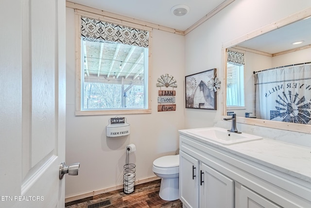 full bathroom featuring visible vents, toilet, ornamental molding, wood finished floors, and vanity