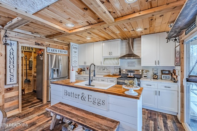 kitchen featuring wooden ceiling, dark wood-style floors, stainless steel appliances, wall chimney exhaust hood, and a sink