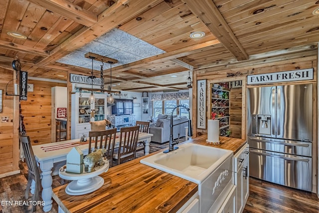 kitchen featuring dark wood-type flooring, stainless steel fridge, wooden ceiling, butcher block counters, and wood walls