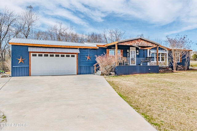 view of front facade featuring a front lawn, an attached garage, driveway, and metal roof