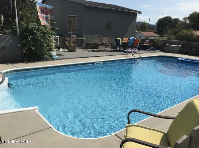 view of swimming pool with a patio area, a fenced in pool, and fence