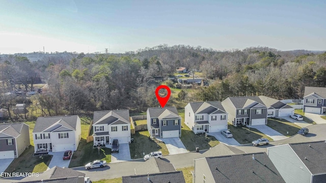 drone / aerial view with a residential view and a wooded view