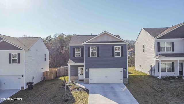 traditional home with an attached garage, stone siding, and driveway