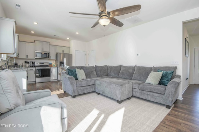 living area featuring a ceiling fan, recessed lighting, dark wood-style floors, and visible vents