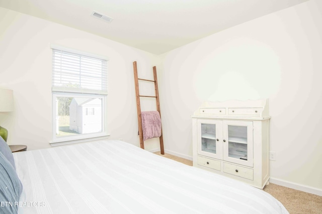 carpeted bedroom with visible vents and baseboards