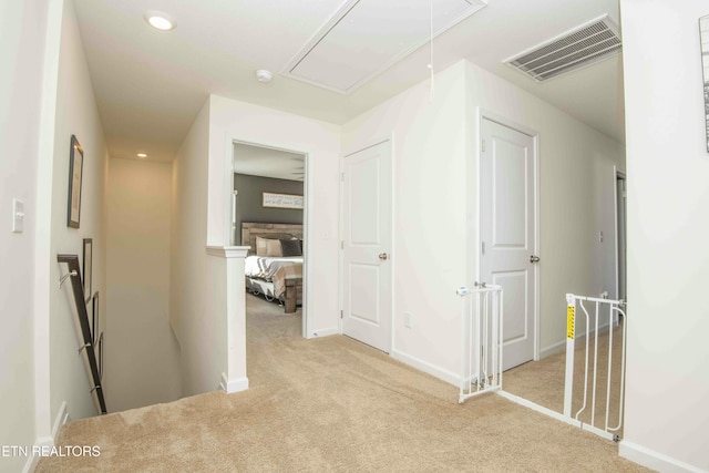 hallway featuring visible vents, attic access, recessed lighting, carpet flooring, and an upstairs landing