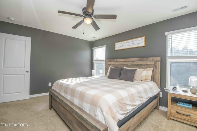 bedroom featuring visible vents, light carpet, baseboards, and ceiling fan