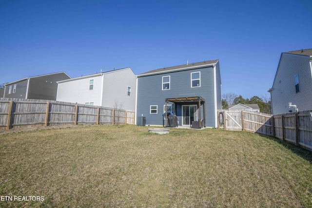 back of house with a yard and a fenced backyard