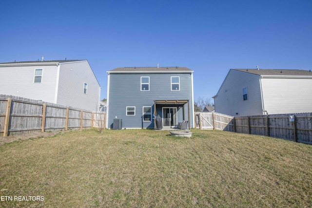 back of house with a fenced backyard, a lawn, and central AC