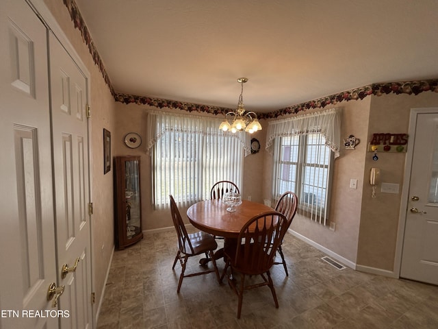 dining space featuring a notable chandelier, visible vents, and baseboards