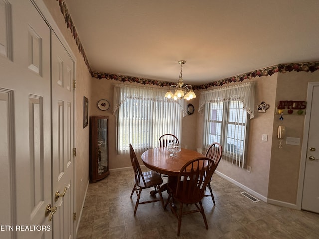 dining space featuring visible vents, baseboards, and an inviting chandelier