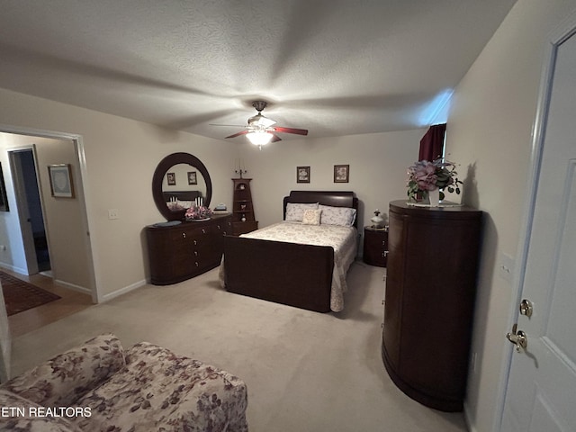 bedroom featuring baseboards, carpet floors, a textured ceiling, and ceiling fan