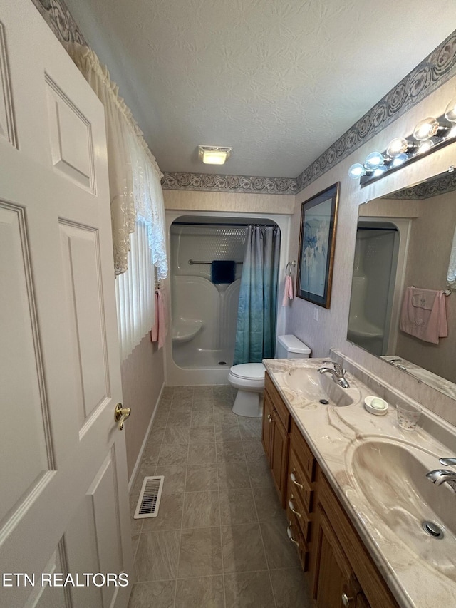 full bath featuring visible vents, a textured ceiling, a shower with curtain, and a sink